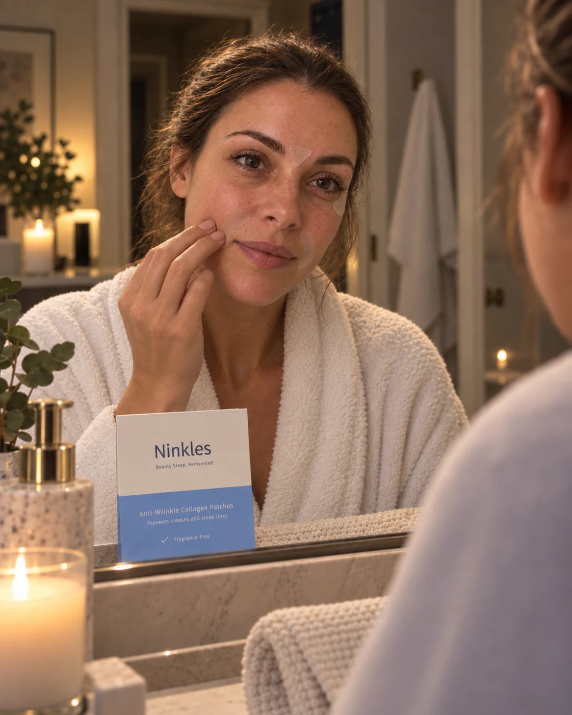 Woman applying a Ninkles patch in the mirror as part of her nighttime routine